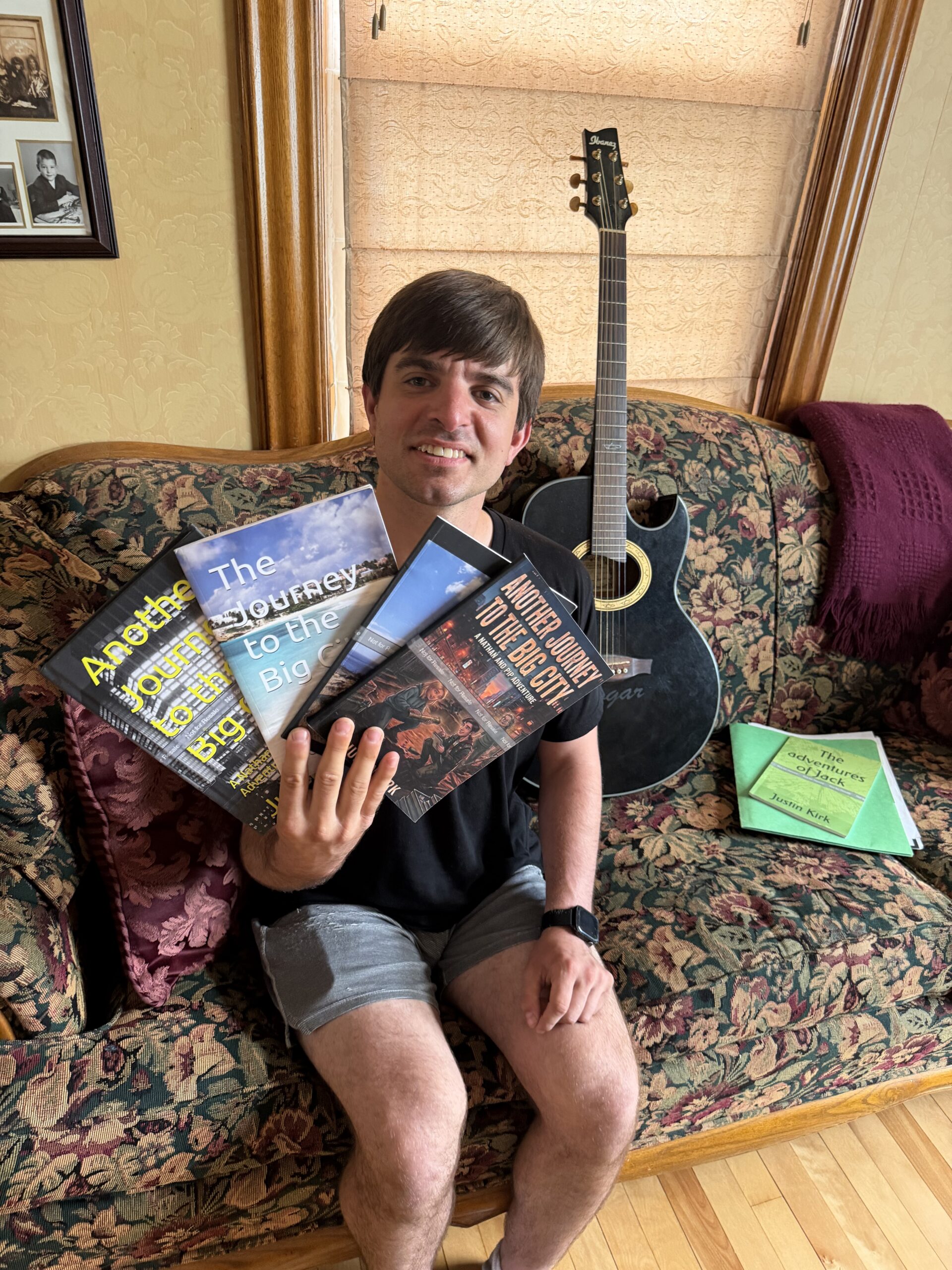 Justin holding the books he authored.